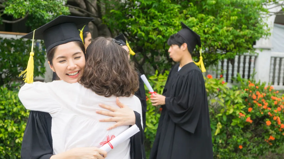 East Asian graduate celebrating with family at graduation ceremony