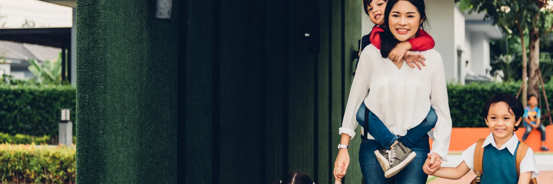 East Asian mother walking happily with her children from home