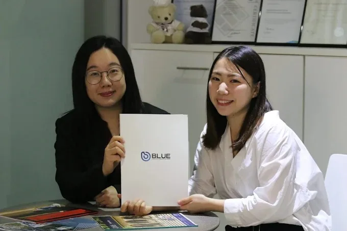 Blue Education advisers holding a branded folder in the office