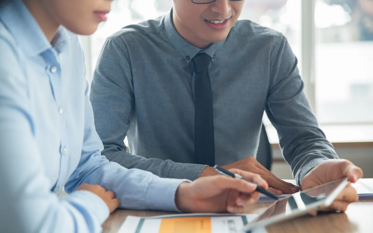 Asian professionals collaborating over documents in a modern office