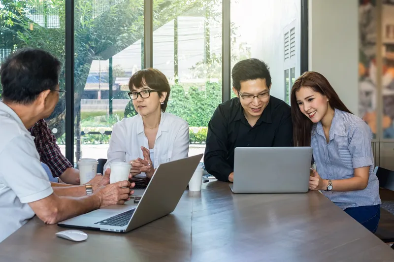 Group of Asian business professionals meeting in a modern office