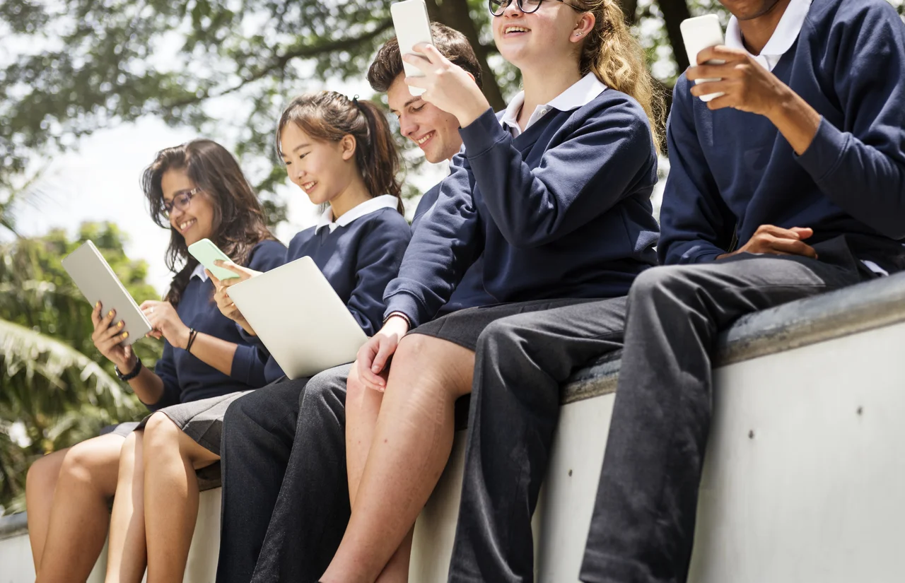 East Asian student smiling in a modern classroom with classmates