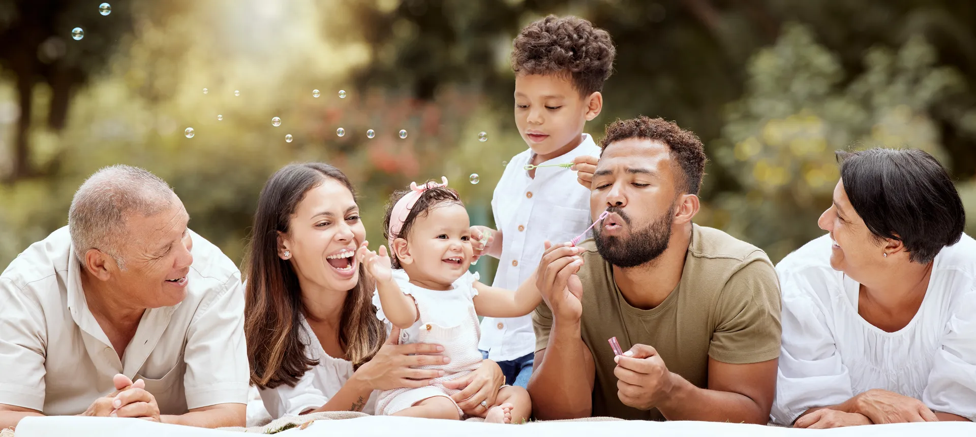 Happy family blowing bubbles together in a sunny garden