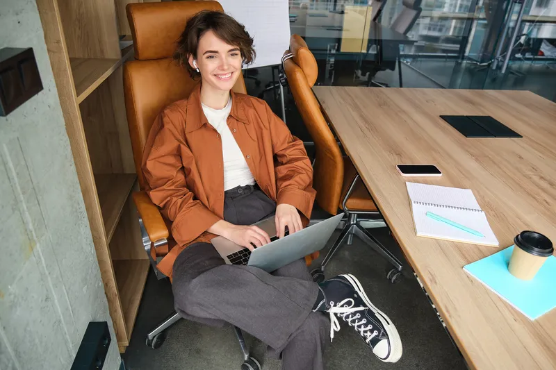 East Asian professional woman working on a laptop in a modern office